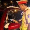 Cảnh sát giao thông lập chốt kiểm tra nồng độ cồn của người tham gia giao thông. (Ảnh: Nguyễn Thanh/TTXVN)