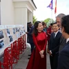 Thứ trưởng Ngoại giao Nguyễn Minh Hằng giới thiệu cho bạn bè quốc tế về triển lãm ảnh. (Ảnh: Anh Hiển/TTXVN)