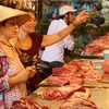 Mua chọn thịt lợn tại chợ Hôm-Đức Viên. (Ảnh: Trần Việt/TTXVN)