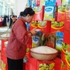 Người tiêu dùng kiểm tra chất lượng của gạo Lanny Rice. (Ảnh: Thanh Tâm/Vietnam+)