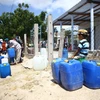 Người dân tại Ninh Thuận nhận nước từ đoàn hỗ trợ. (Ảnh: Minh Quyết/TTXVN)