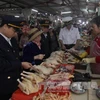 Nhân viên Chi cục thú y kiểm tra cơ sở kinh doanh thịt gia cầm tại chợ. (Ảnh: Vũ Sinh/TTXVN)