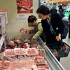 Khách hàng lựa chọn thịt bò. (Ảnh: AFP/TTXVN)