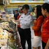 Đoàn thanh tra liên ngành kiểm tra các mặt hàng thực phẩm được bày bán tại siêu thị. (Ảnh: Quốc Dũng/TTXVN)