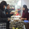 Người tiêu dùng lựa chọn nấm hương rừng tại Hội chợ Xuân Đinh Dậu (Ảnh: Thanh Tâm/Vietnam+)