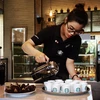 Nhân viên Starbucks giới thiệu đồ uống với thực khách tại cửa hàng mới khai trương. (Ảnh: PV/Vietnam+)