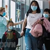 Nhân viên y tế Singapore theo dõi thân nhiệt hành khách qua máy quét tại sân bay quốc tế Changi ngày 22/1/2020. (Ảnh: AFP/TTXVN)