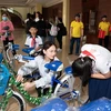Hoa hậu Mai Phương trao xe đạp cho các em học sinh có hoàn cảnh khó khăn. (Ảnh: CTV/Vietnam+)