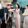 Hoa hậu Thanh Thủy tặng khăn rằn và nón lá cho đoàn khách đặc biệt đến từ Nhật Bản. (Ảnh: CTV/Vietnam+)
