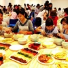 Các bạn học sinh, sinh viên Việt Nam tự mình làm các món ăn Hàn Quốc. (Ảnh: Thanh Hà/TTXVN)