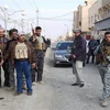 Các tay súng vũ trang và binh sỹ Iraq đứng bảo vệ tại một đường phố ở thành phố Ramadi của Iraq. (Nguồn: AFP)