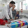 Bác sỹ Bệnh viện Nhi Đồng 1 thăm khám cho bệnh nhi bị sốt xuất huyết. (Ảnh: Phương Vy/TTXVN)