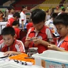 Các thí sinh lắp ráp và lập trình trên máy tính trong cuộc thi Robothon 2014. (Nguồn: TTXVN)