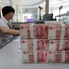 Kiểm tiền đồng nhân dân tệ tại ngân hàng ở Liên Vận Cảng, tỉnh Giang Tô, miền đông Trung Quốc ngày 11/8 vừa qua. (Ảnh: AFP/TTXVN)