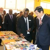 Chủ tịch nước Trương Tấn Sang xem các sản phẩm phục vụ cho công nghệ thông tin của Khu chế xuất Ubungo. (Ảnh: Nguyễn Khang/TTXVN)