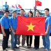 Các đoàn viên tự hào tặng cờ Tổ quốc cho ngư dân. (Ảnh: Nguyễn Thanh/TTXVN) 