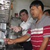 Chủ tịch UBND Thành phố Hồ Chí Minh Nguyễn Thành Phong kiểm tra việc thực hiện cung cấp nước sạch bằng thiết bị lọc nước tại hộ gia đình ông Lê Vũ Hồng ở ấp Bến Mương, xã An Nhơn Tây. (Ảnh: Thanh Vũ/TTXVN)