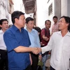 Bí thư Thành ủy Thành phố Hồ Chí Minh Đinh La Thăng thăm hỏi người dân nghèo sống trên và ven kênh Đôi (quận 8). (Ảnh: Thanh Vũ/TTXVN)