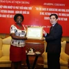 Bộ trưởng Nông nghiệp và Phát triển Nông thôn Cao Đức Phát trao kỷ niệm chương cho bà Victoria Kwakwa. (Ảnh: Vũ Sinh/ TTXVN) 