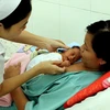 Nhân viên y tế hướng dẫn cách chăm sóc trẻ bằng phương pháp 'da kề da.' (Ảnh: Dương Ngọc/TTXVN)