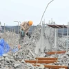 Công nhân tiến hành khoan, phá dỡ phần công trình xây dựng trái phép ở toà nhà số 8B Lê Trưc, Hà Nội, sáng 6/3. (Ảnh: Minh Đức/TTXVN)