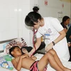 Y, bác sỹ thăm khám cho bệnh nhân sốt xuất huyết tại Bệnh viện Đa khoa tỉnh Đắk Lắk. (Ảnh: Dương Giang/TTXVN)