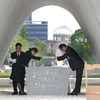 Thị trưởng Hiroshima Kazumi Matsui (phải) trao danh sách những nạn nhân bom nguyên tử cho một nạn nhân tại Công viên tưởng niệm Hòa bình. (Nguồn: AFP)