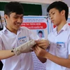 Lê Ngô Duy Phong (bên trái ảnh) đang hướng dẫn sử dụng găng tay thông minh. (Nguồn: Husta.org)