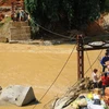 Hàng tiếp tế được vận chuyển bằng cáp treo qua chiếc cầu đã bị sập đến hai thôn Sủng Hoảng 1, Sủng Hoảng 2. (Ảnh: Hương Thu/TTXVN) 
