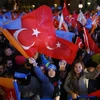 Một số người phụ nữ vẫy cờ bên ngoài trụ sở Quốc hội Thổ Nhĩ Kỳ. (Nguồn: Reuters)