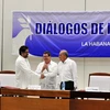 Đại diện của Chính phủ Colombia và FARC bắt tay sau khi được Ngoại trưởng Cuba Bruno Rodríguez (giữa) trao tượng trưng hai phiên bản thỏa thuận. (Ảnh: Lê Hà/TTXVN)