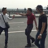Nhà báo Quang Thế (áo trắng) bị hành hung khi đang tác nghiệp trên cầu Nhật Tân. (Nguồn: Báo Tuổi Trẻ)