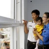Niềm vui của một gia đình trong ngày nhận bàn giao nhà ở xã hội ở Thành phố Hồ Chí Minh. (Ảnh: Hoàng Hải/TTXVN)