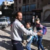 Sơ tán các em học sinh khỏi một trường học sau khi ngôi trường này bị phiến quân tấn công ở Aleppo ngày 20/11. (Nguồn: AFP/TTXVN)