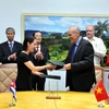 Đại diện công ty Davac của Việt Nam và Viện Vắcxin Finlay của Cuba trao đổi văn bản thỏa thuận về cùng phát triển vắcxin chống thương hàn. (Ảnh: Vũ Lê Hà/TTXVN)