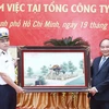 Thủ tướng Nguyễn Xuân Phúc tặng quà lưu niệm cho Tổng Công ty Tân Cảng Sài Gòn. (Ảnh: Thống Nhất/TTXVN)