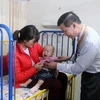 Bác sỹ Pau Kieu Kong đang thăm khám cho bệnh nhi. (Ảnh: Hoàng Nhương/Vietnam+)