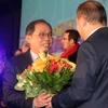Thị trưởng Didier Guillaume đã tặng hoa Đại sứ Nguyễn Ngọc Sơn tại buổi lễ. (Ảnh: Bích Hà/Vietnam+)