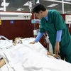 Bác sỹ Nguyễn Văn Toại, Trưởng khoa Phẫu thuật gây mê hồi sức, Bệnh viện Đa khoa tỉnh Bắc Ninh đang thăm khám cho bệnh nhân. (Ảnh: Thanh Thương/TTXVN)