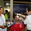Bác sỹ Việt Nam và Lào đang tiến hành kiểm tra, mở băng mắt cho một bệnh nhân sau khi mổ. (Ảnh minh họa: TTXVN)