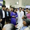 Bộ trưởng Nguyễn Thị Kim Tiến tiếp xúc với người bệnh để kiểm tra công tác chuyên môn tại Bệnh viện Đa khoa Xanh Pôn. (Ảnh: Dương Ngọc/TTXVN)