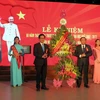Chủ tịch Ủy ban Nhân dân tỉnh Thừa Thiên-Huế Nguyễn Văn Cao (bên phải) tặng hoa chúc mừng Trường Đại học Sư phạm Huế nhân kỷ niệm 60 năm thành lập. (Ảnh: Quốc Việt/TTXVN)