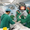 Êkíp bác sỹ đưa camera vào ổ bụng bệnh nhân để chuẩn bị thực hiện phẫu thuật ca ung thư dạ dày đầu tiên bằng robot. (Ảnh: Phương Vy/TTXVN)