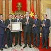 Chủ tịch nước Trần Đại Quang tặng quà cho Đoàn đại biểu kiều bào Việt Nam tại Thái Lan. (Ảnh: Nhan Sáng/TTXVN)