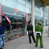 Lực lượng chức năng thành phố Móng Cái tháo dỡ biển kinh doanh của điểm mua sắm ASEAN vì vi phạm quy định trong hoạt động thương mại. (Ảnh: Văn Đức/TTXVN)