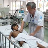 Bác sỹ Đặng Thanh Tuấn, Trưởng khoa Hồi sức ngoại thăm khám cho bệnh nhi. (Ảnh: Phương Vy/TTXVN)