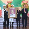 Chủ tịch nước Trần Đại Quang tặng bức chân dung Chủ tịch Hồ Chí Minh cho Ban Cơ yếu Trung ương cục miền Nam. (Ảnh: Nhan Sáng/TTXVN)