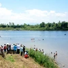 Lực lượng cứu hộ tìm kiếm thi thể học sinh bị đuối nước trên sông Ba. (Ảnh: Thế Lập/TTXVN)