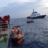Các xuồng của Việt Nam cập mạn tàu Indonesia để đón ngư dân. (Ảnh: Đỗ Quyên/TTXVN)