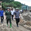 Bộ trưởng Trương Minh Tuấn (bên phải) thị sát vùng thiệt hại do lũ. (Ảnh: Đinh Hữu Dư/TTXVN)